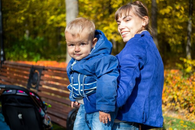 babyjongen met vuil op gezicht glimlacht naar de camera en zit in moeders armen vrouw kijkt naar zoon en glimlacht