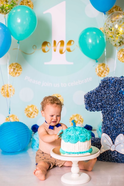 Babyjongen spelen met een taart tijdens cake smash verjaardagsfeestje