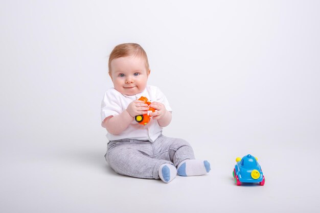 Babyjongen spelen met speelgoedauto's op witte achtergrond