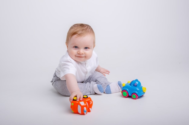 Babyjongen spelen met speelgoedauto's op witte achtergrond