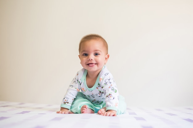 Babyjongen zittend op het bed