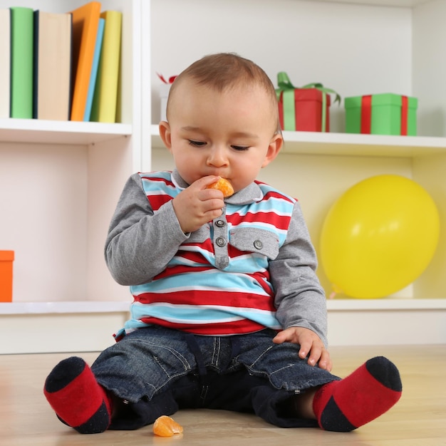 Babykind dat mandarijn oranje fruit eet