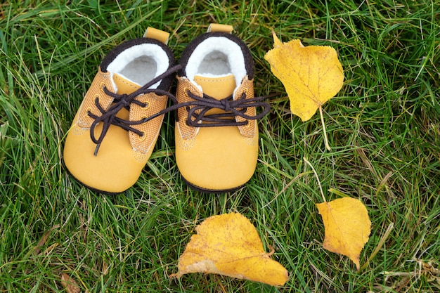 Babylaarzen in het bos. Kid schoenen met herfstbladeren buitenshuis.