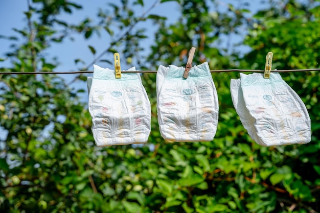 Babyluiers hangen aan wasknijpers tegen de lucht. het concept van zomervakantie met kinderen.