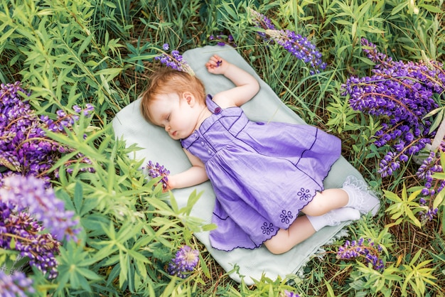 Babymeisje 1 jaar oud slapen in de natuur tussen de bloemen