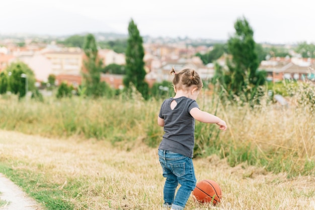 Babymeisje bal spelen in een veld