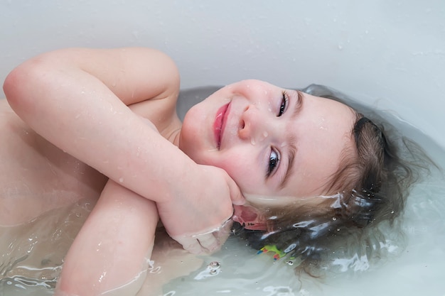 Babymeisje die tonend gezicht net boven waterspiegel glimlachen