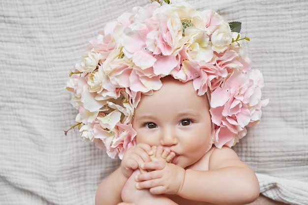 Babymeisje in bloemenhoed Ansichtkaart Moederdag en Pasen Kinderbeschermingsdag Wereldgeluksdag Glimlachend kind