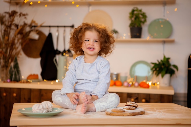 Babymeisje in pyjama's in de keuken