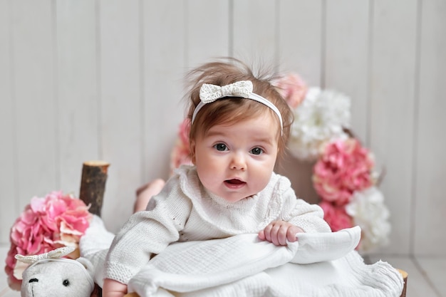 Babymeisje met bloemen en speelgoed ansichtkaart moederdag en pasen kinderbeschermingsdag wereldgeluksdag glimlachend kind