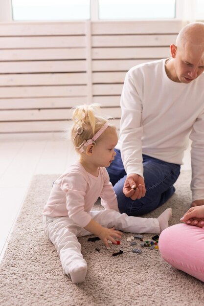 Babymeisje met cochleaire implantaten die thuis met haar vader spelen Doofheid en medisch technologieconcept