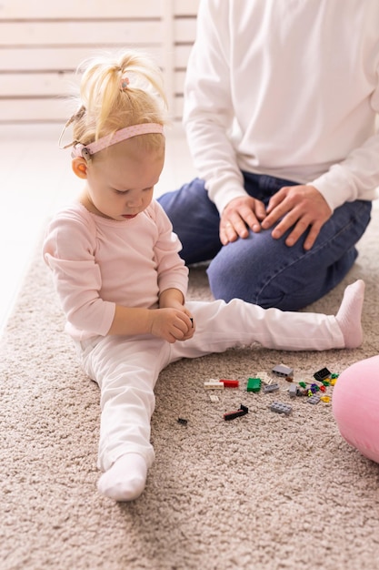 Babymeisje met cochleaire implantaten die thuis met haar vader spelen Doofheid en medisch technologieconcept