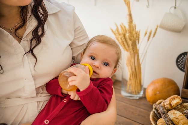 Babymeisje met een fles appelsap