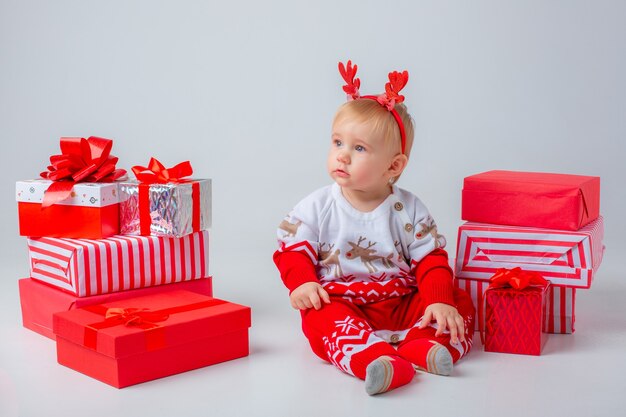 Babymeisje met geschenken op een witte achtergrond geïsoleerd kerstmis nieuwjaar