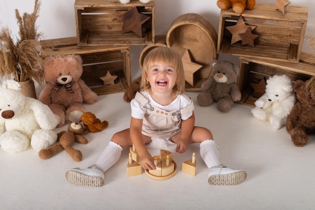 Babymeisje op een witte achtergrond met een taart en teddyberen.