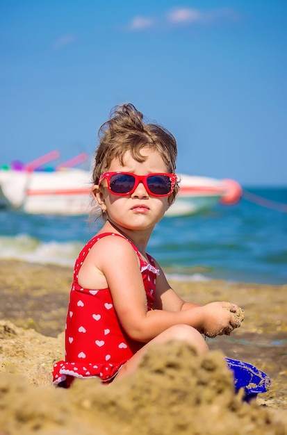 Babymeisje op het strand, door de zee. Selectieve aandacht.