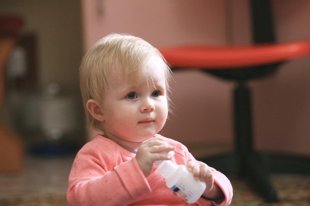 Babymeisje-peuter eet thuis vitamines of pillen, telefoto