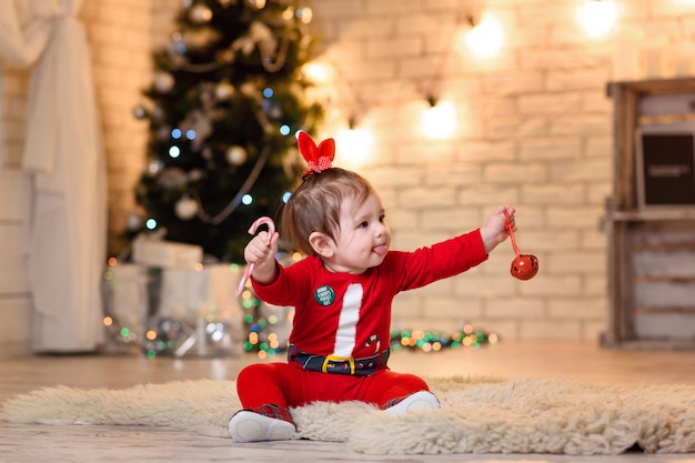 Babymeisje poseren in kostuum van de kerstman