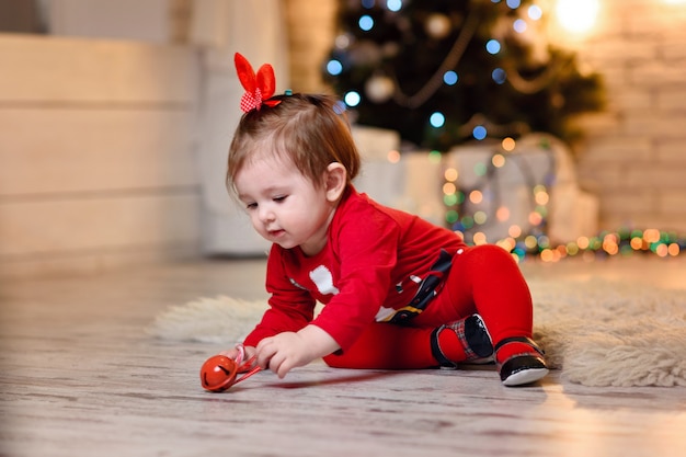 Babymeisje poseren in kostuum van de kerstman