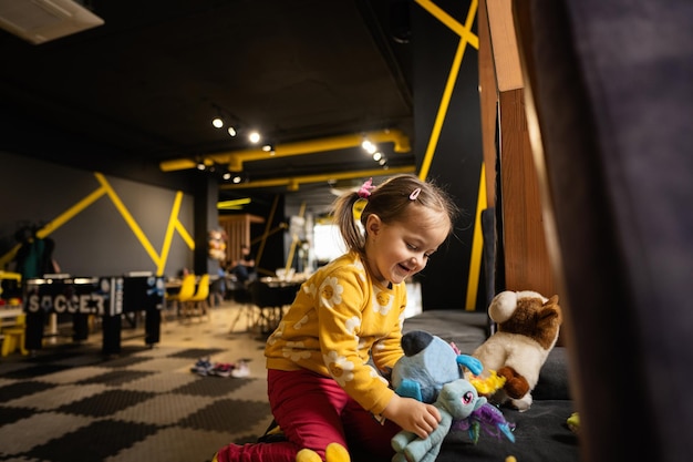 Babymeisje spelen met zacht speelgoed op moderne kleuterschool