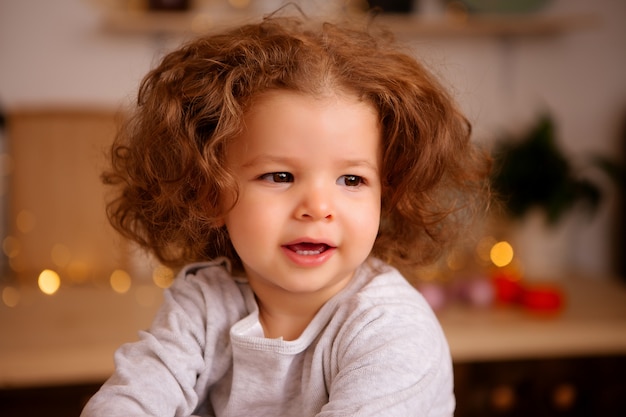 babymeisje zit in de keuken van Kerstmis op tafel