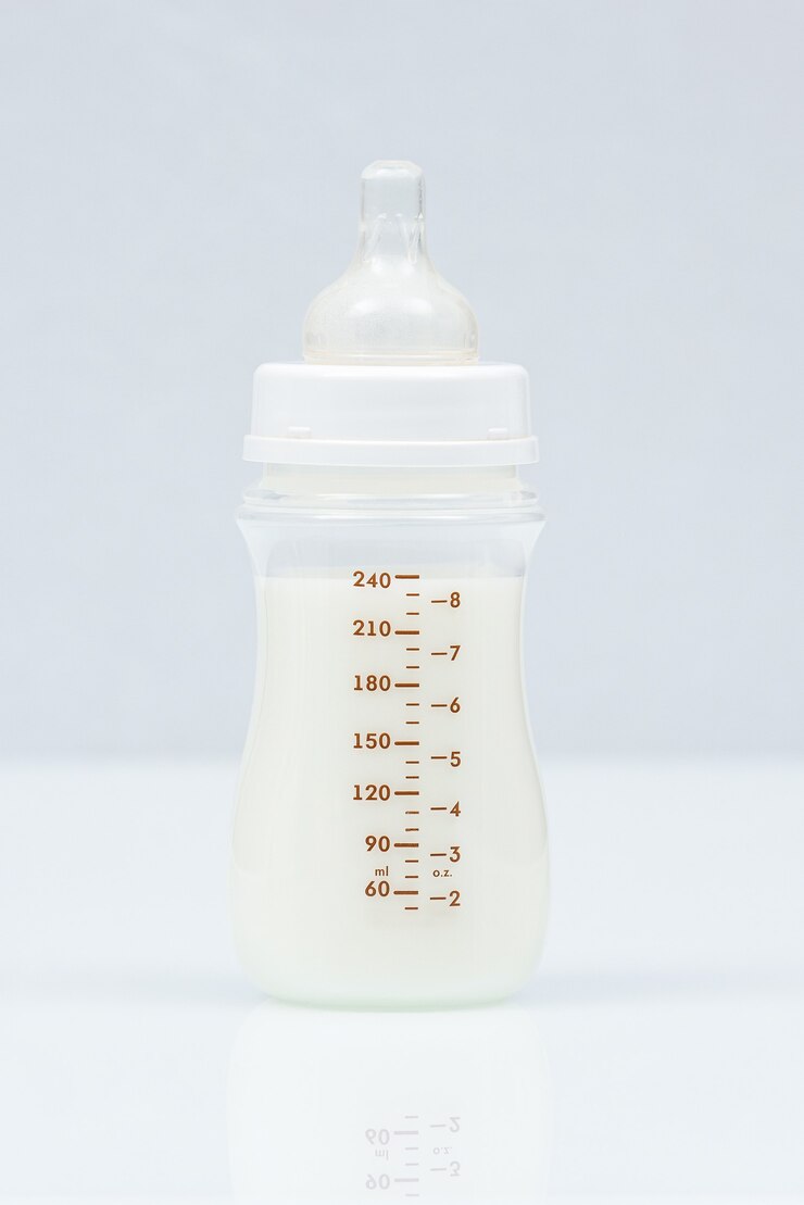 Babymelkfles op een lichte achtergrond. Volle babymelkfles