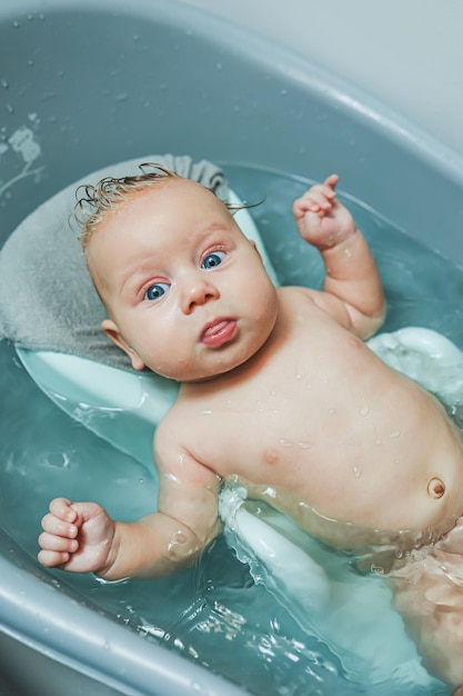 Babys first baths Caring for a newborn baby Bathing a baby in a bathtub A newborn baby is bathing in the water