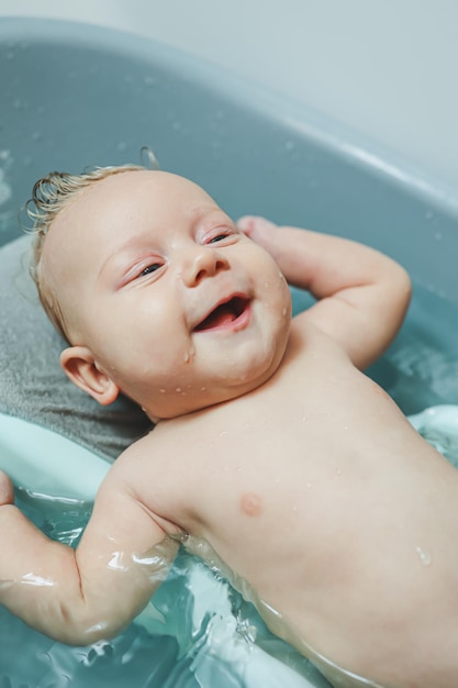 Babys first baths Caring for a newborn baby Bathing a baby in a bathtub A newborn baby is bathing in the water