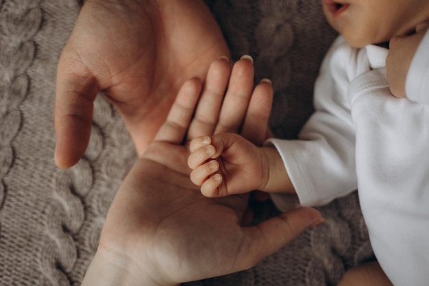 赤ちゃんの手が赤ちゃんの 手を握っている