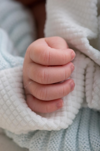 Photo a babys hand wrapped in a white knitted sweater