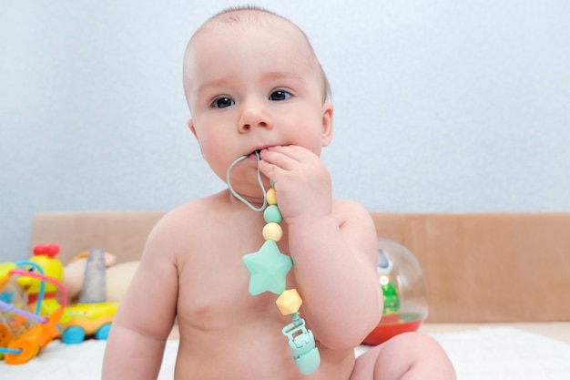 I denti da latte del bambino stanno spuntando, le gengive prudono. il bambino ha un giocattolo in bocca