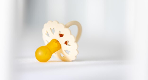 Photo babys pacifier on a blurred white background