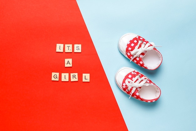 Babyschoenen of peuterschoenen met opschrift "It's a girl" of "It's a boy", bovenaanzicht.