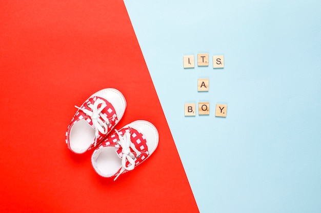 Babyschoenen of peuterschoenen met opschrift "It's a girl" of "It's a boy", bovenaanzicht.