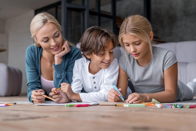 Babysitter helping childrens to do homework Fun time together