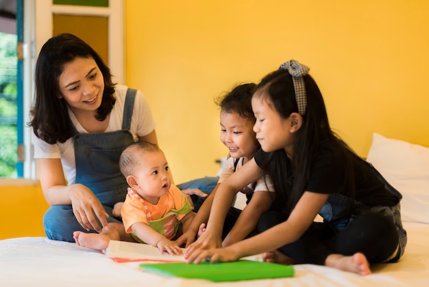 ベビーシッターは、ベッドを持っている3人の愚かな遊び心のある子供たちと遊んでいます。