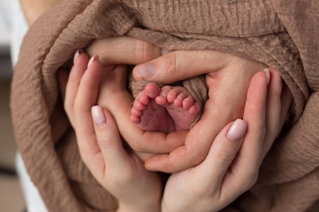 Babyvoeten in de handen van de moeder Benen van een kleine pasgeborene in de armen close-up Familie en kind Gelukkig fa