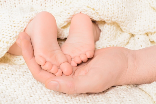 Babyvoeten op mannenhand met zachte close-up als achtergrond