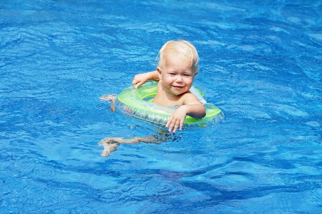 Babyzwemmen in het blauwe zwembadwater