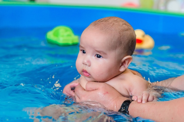 Babyzwemmen in het zwembad met een gezondheidscoach, waterbehandelingen voor het kind