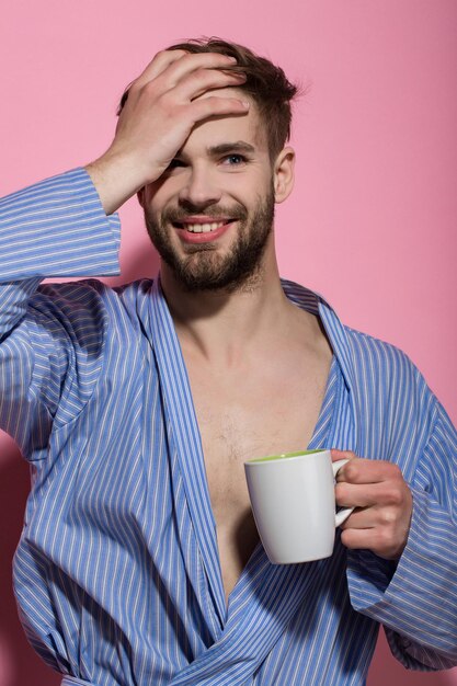 Bachelor in blue dressing gown smile with mug