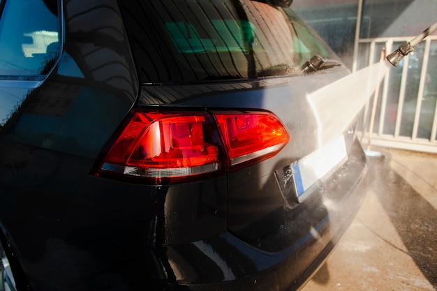 Sul retro di un'auto nera pulita con acqua