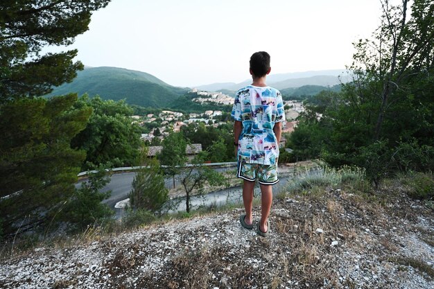 Back of boy stand and look in view of Nocera Umbra town and comune in the province of Perugia Italy