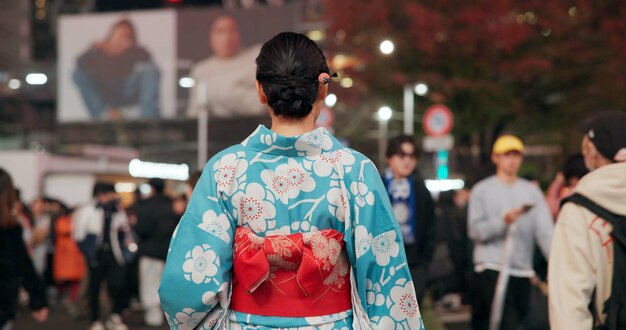 Photo back city and japanese woman on street at night with crowd for culture heritage or tradition travel fashion kimono and person walking on road of urban tokyo town for vacation or sightseeing