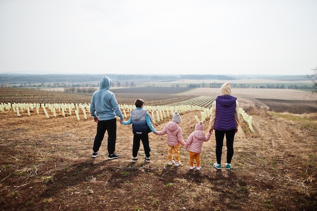 Back of family stand against vineyard in early spring