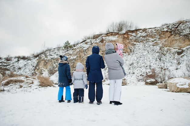 冬の屋外の母親と4人の子供たちの家族の背中