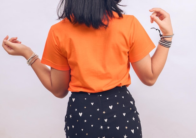Задняя девушка или женщина в пустой оранжевой футболке на изолированном фоновом макете