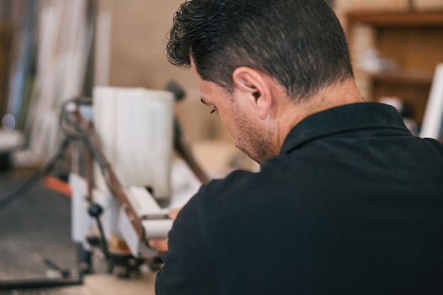 Back of a man on a furniture construction workshop