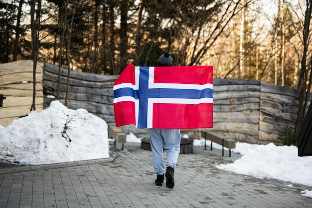 Back of man holding Norway flag Scandinavian culture norwegian people