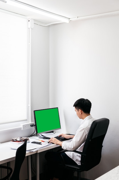 Back of the man wearing white shirt and sit on black office chair